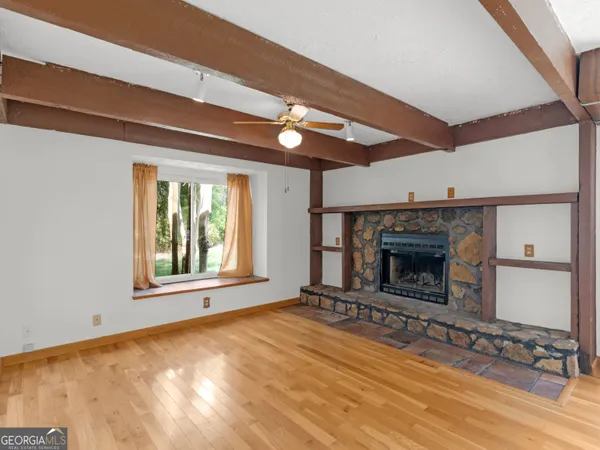 a view of an empty room with a fireplace and window