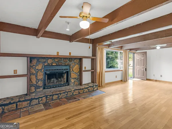 a view of an empty room with a fireplace and a window