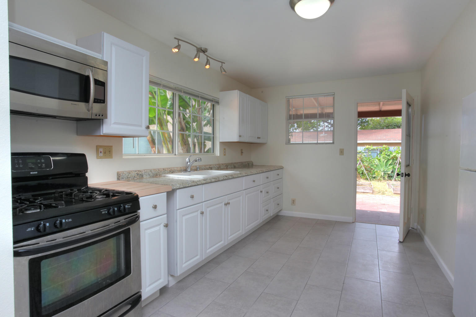 1035 Cramer Road, Unit B Carpinteria, CA 93013 - Photo 5 of 12 a kitchen with stainless steel appliances granite countertop a stove a sink and a microwave
