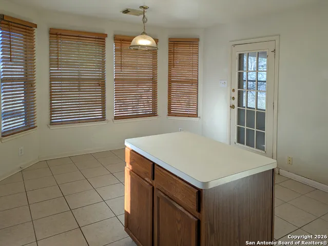 an empty room with wooden floor chandelier fan and windows