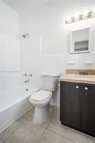 a bathroom with a toilet a sink a mirror and bathtub