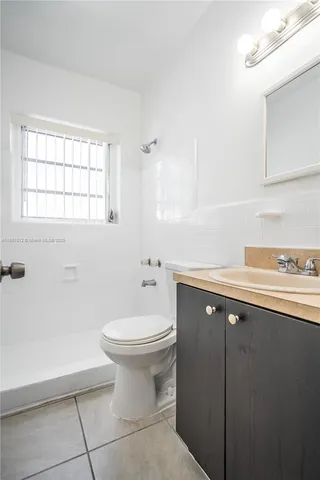 a bathroom with a sink toilet and window