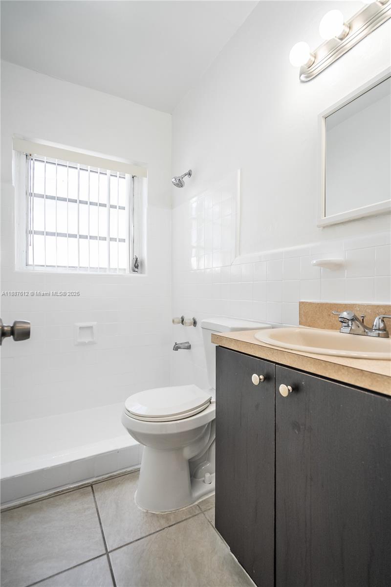 8300 Abbott Avenue, Unit 17 Miami Beach, FL 33141 - Photo 7 of 16 a bathroom with a sink toilet and window