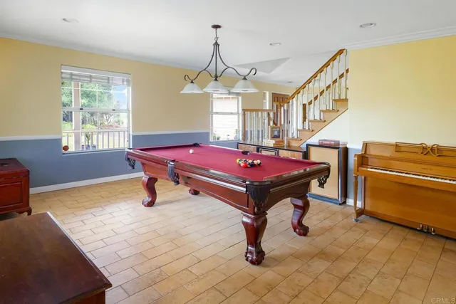 a room with pool table and a chandelier