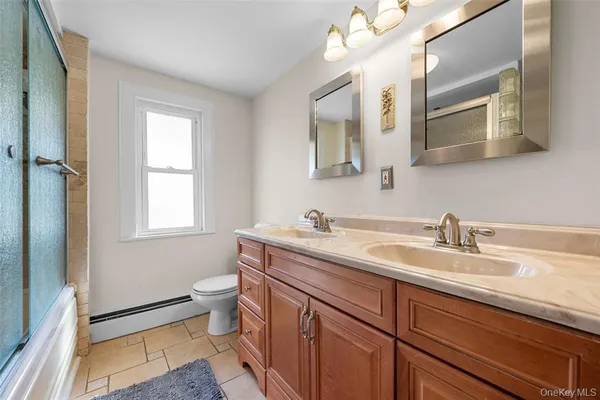 a bathroom with a granite countertop sink mirror and a toilet
