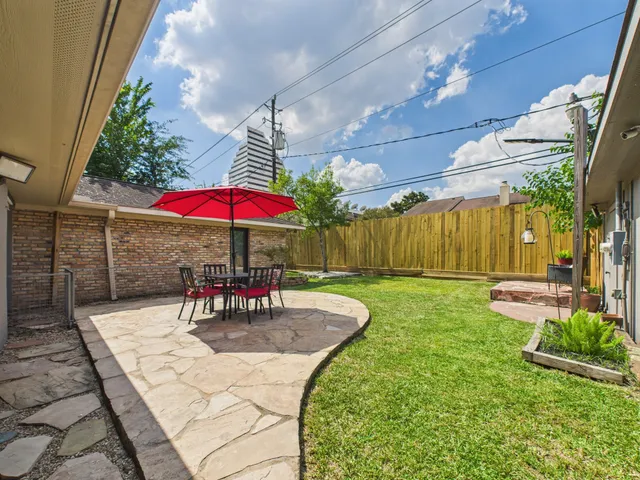 a view of a patio with a table and chairs under an umbrella