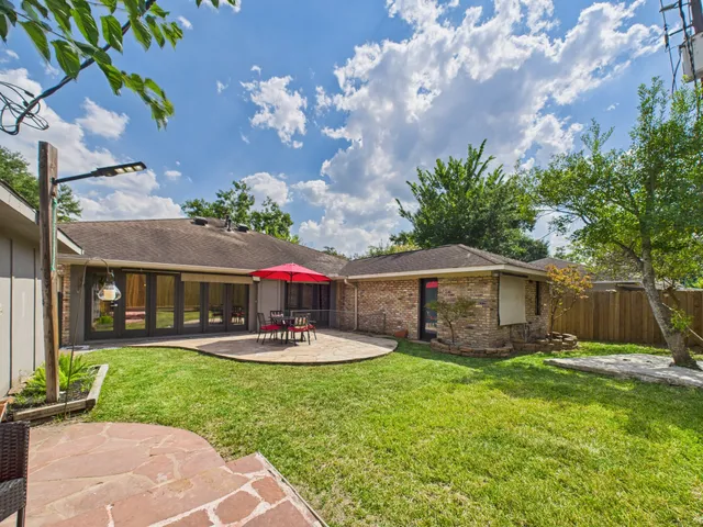 a view of a backyard with a patio and dining space