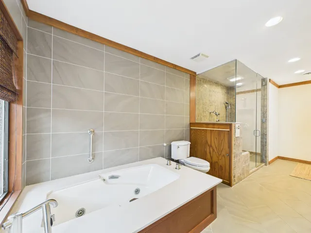 a bathroom with a large tub shower and sink
