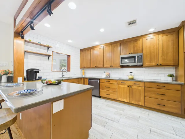 a kitchen with stainless steel appliances granite countertop a sink counter space and cabinets