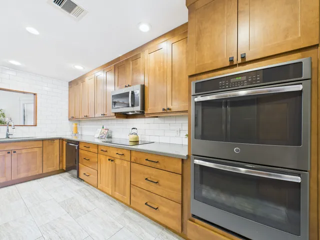 a kitchen with sink a stove and cabinets