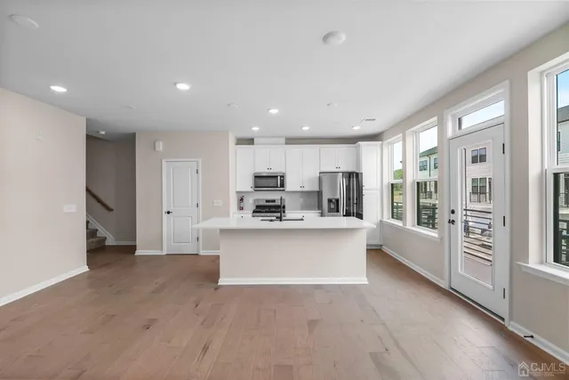 a view of kitchen with sink and refrigerator