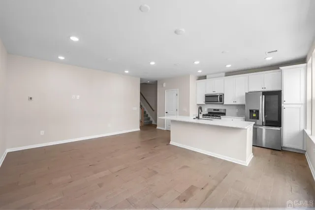 a large white kitchen with stainless steel appliances lots of counter top space