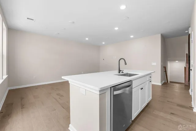 a kitchen with a sink and wooden floor