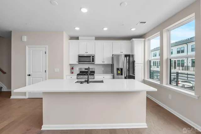 a large kitchen with kitchen island a stove a sink and a refrigerator