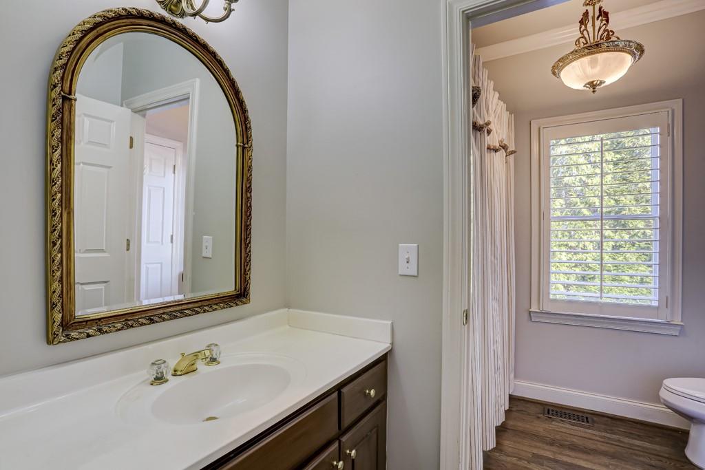 5940 Whitestone Lane Suwanee, GA 30024 - Photo 32 of 63 a bathroom with a granite countertop sink a toilet and a mirror