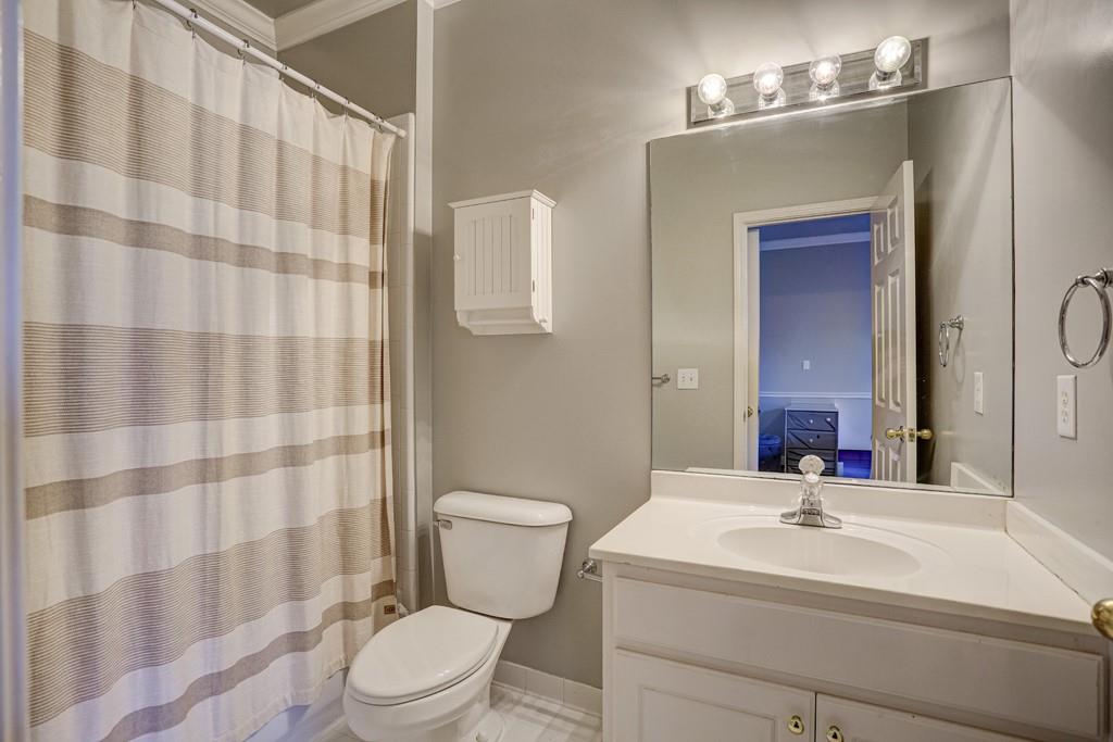 5940 Whitestone Lane Suwanee, GA 30024 - Photo 50 of 63 a bathroom with a sink a toilet a mirror and shower curtain