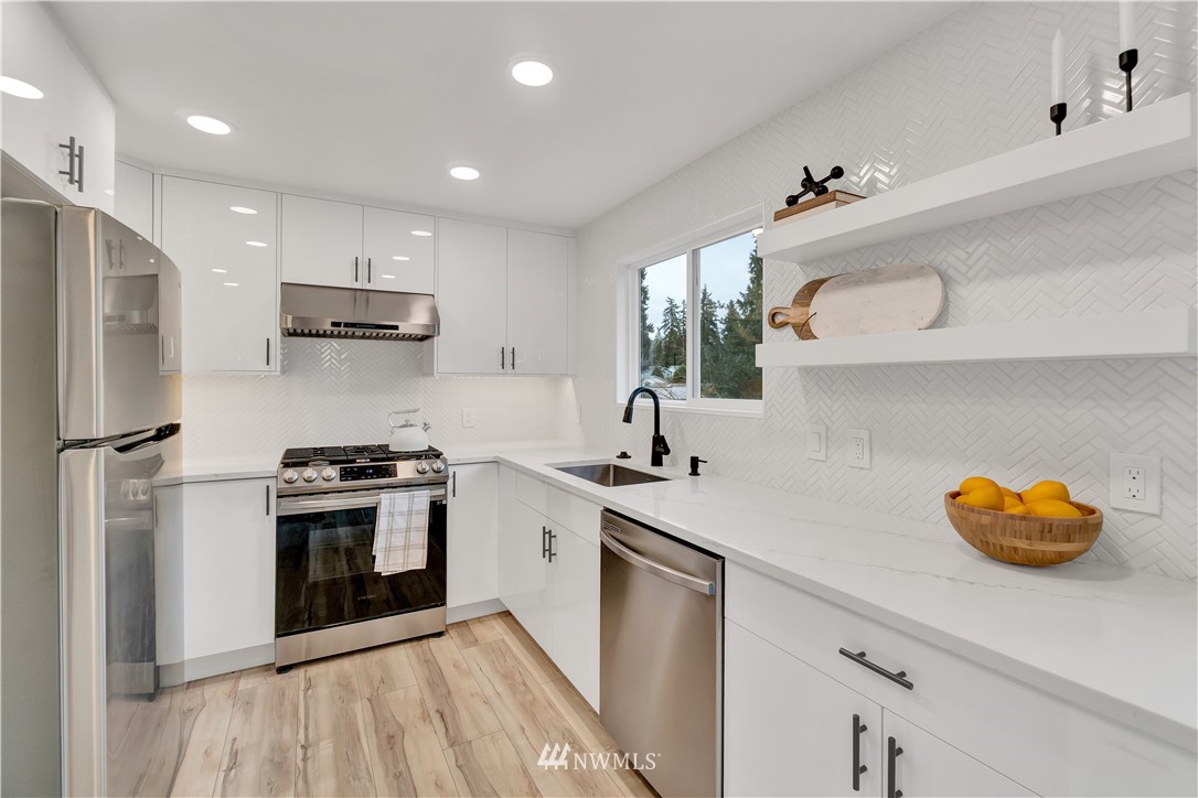 4606 237th Place Southwest Mountlake Terrace, WA 98043 - Photo 14 of 40 a kitchen with stainless steel appliances granite countertop a sink a stove and a refrigerator