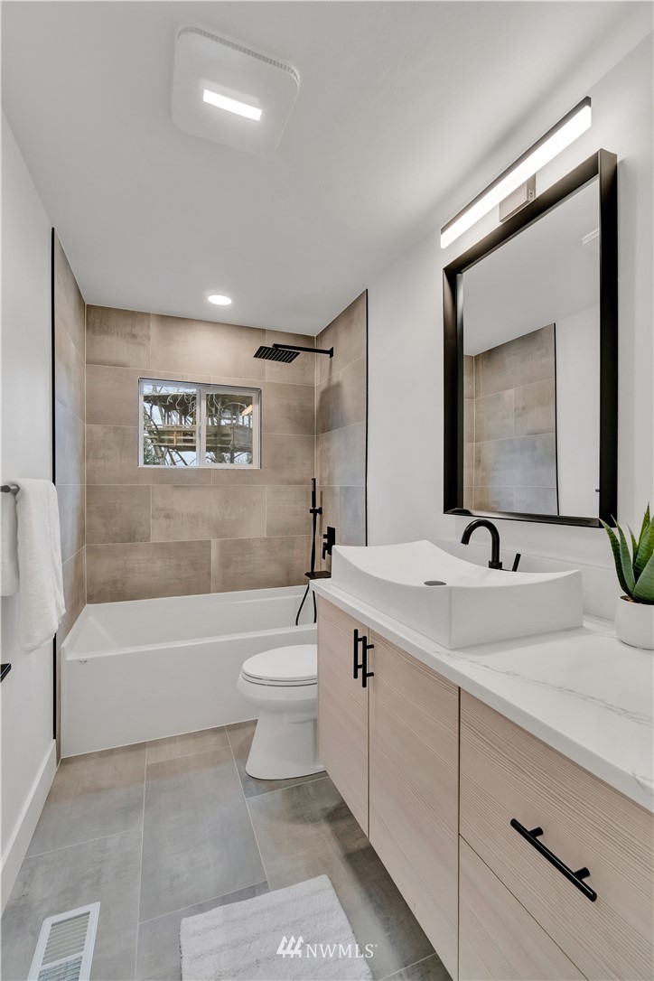 4606 237th Place Southwest Mountlake Terrace, WA 98043 - Photo 18 of 40 a bathroom with a toilet a sink a mirror and bathtub