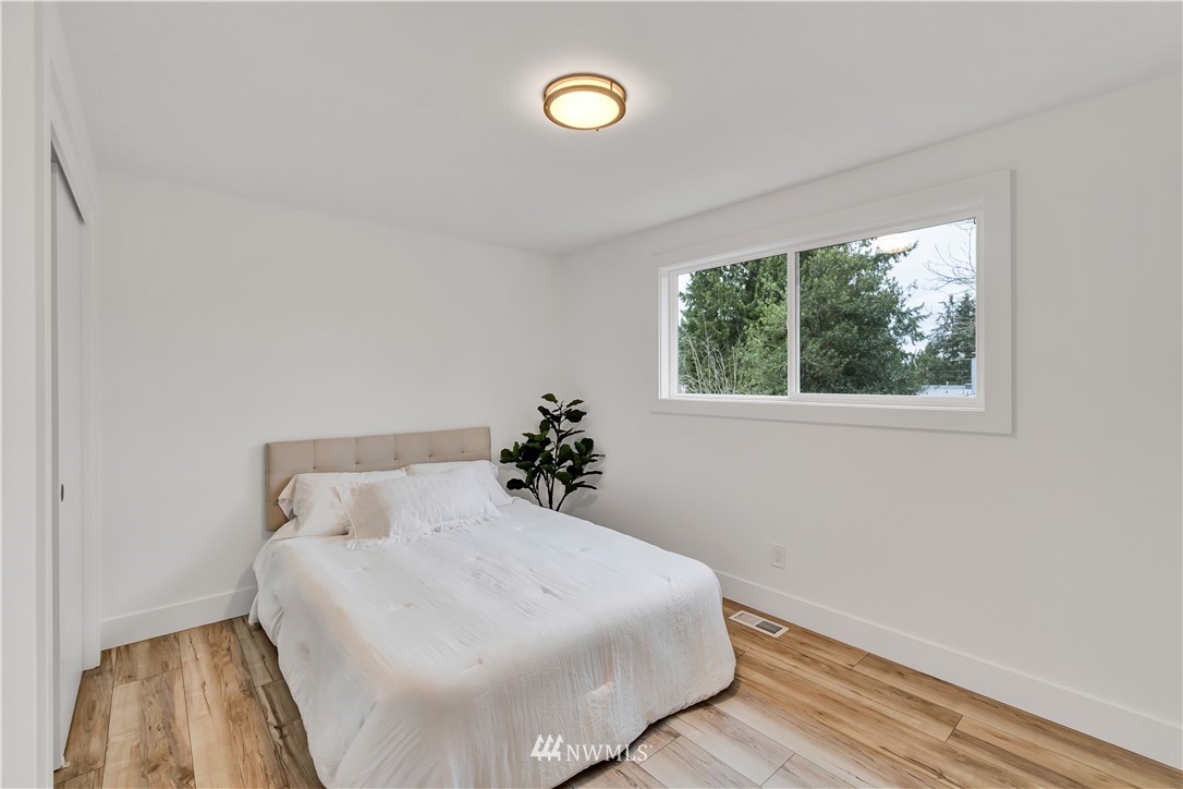 4606 237th Place Southwest Mountlake Terrace, WA 98043 - Photo 19 of 40 a bedroom with a white bed and wooden floor