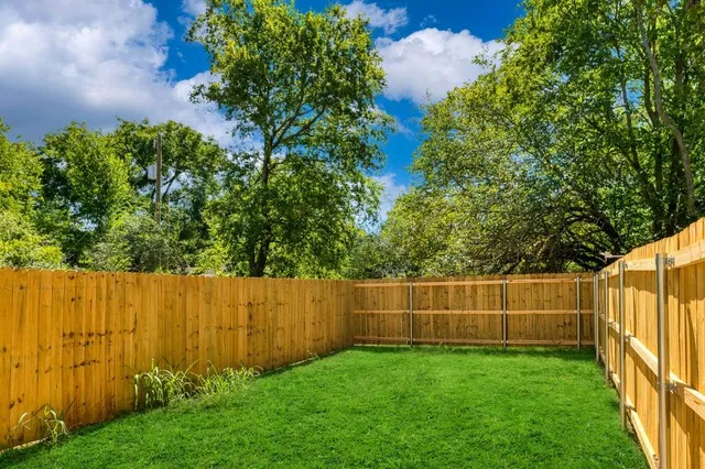 a view of a backyard with wooden fence