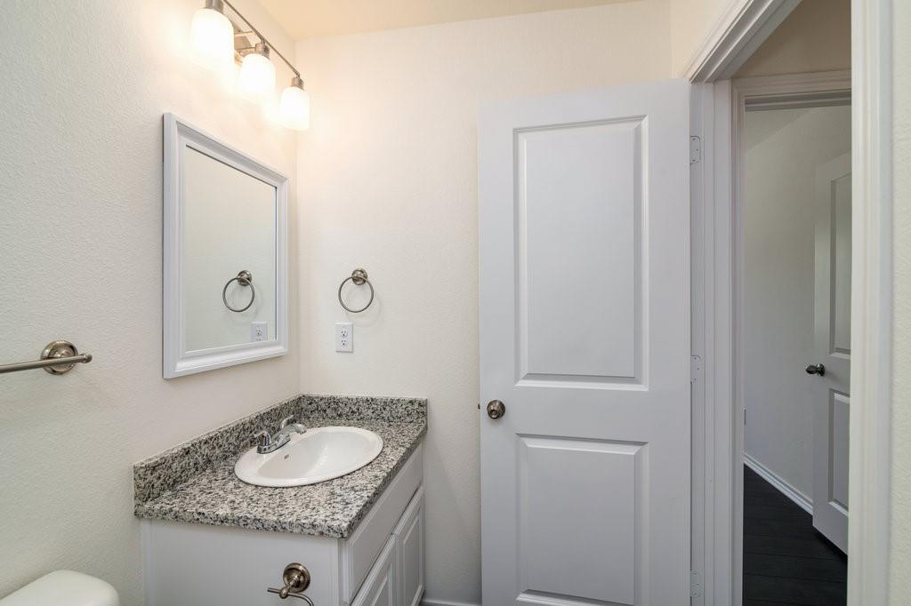 803 South 6th Street Bonham, TX 75418 - Photo 10 of 19 a bathroom with a granite countertop sink and a mirror