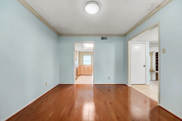 a view of empty room with wooden floor and fireplace