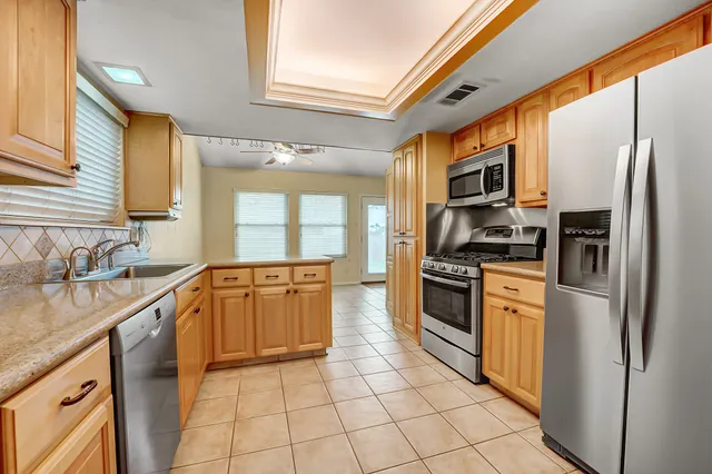 a kitchen with stainless steel appliances granite countertop a sink and a cabinets