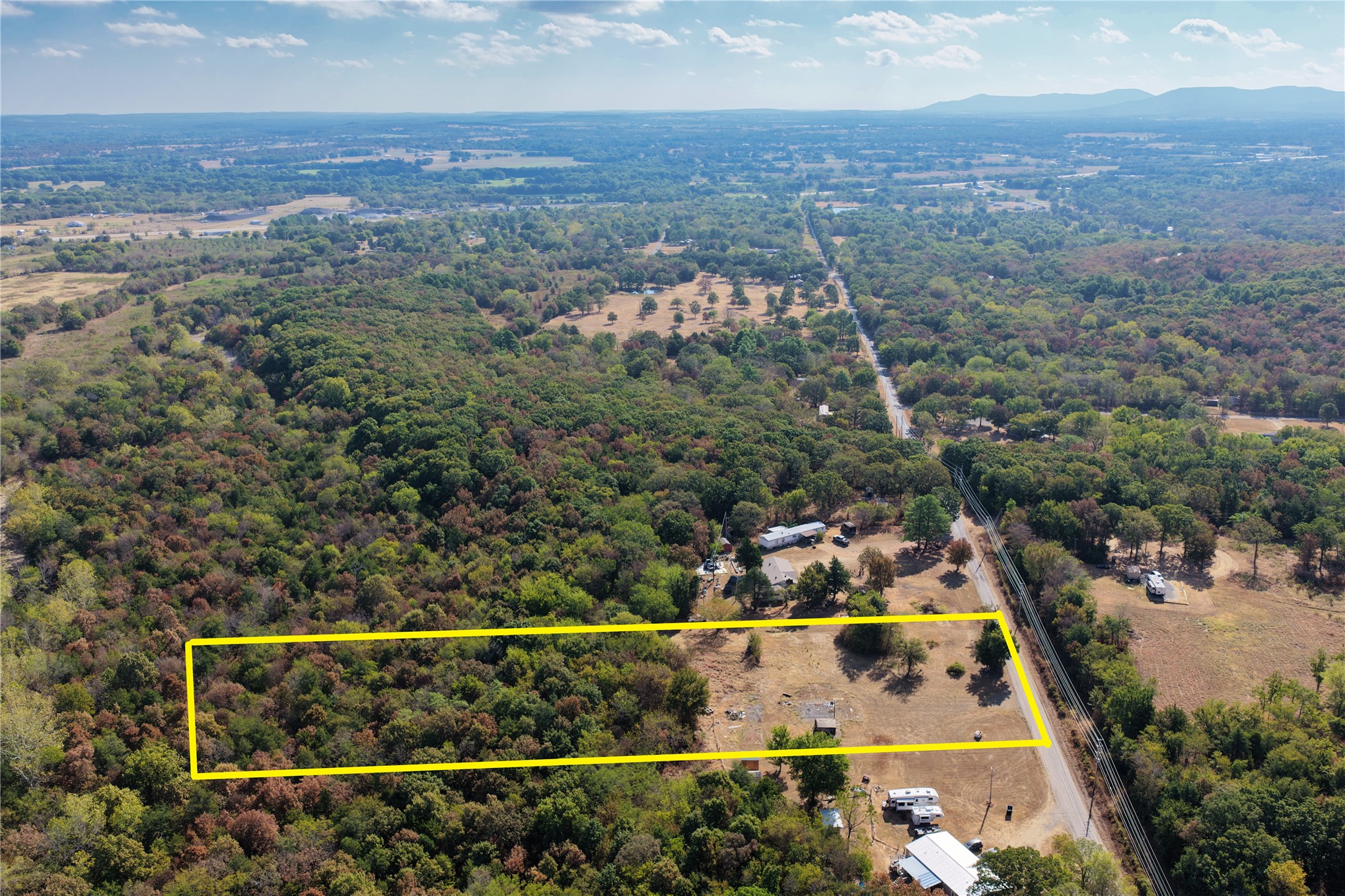 Expansive rural lot featuring mature trees and partial clearing