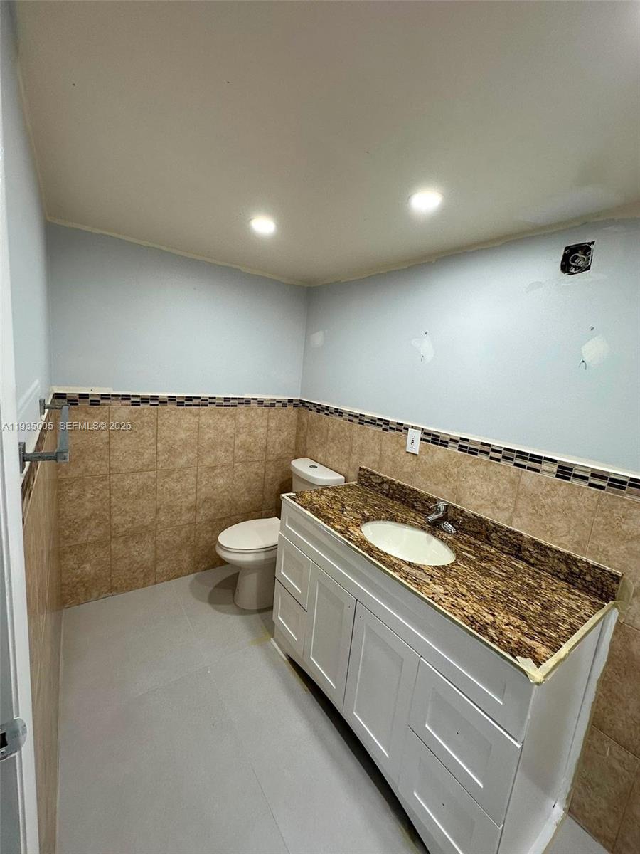 9440 Southwest 8th Street, Unit 402 Boca Raton, FL 33428 - Photo 17 of 45 a bathroom with a granite countertop sink and a toilet