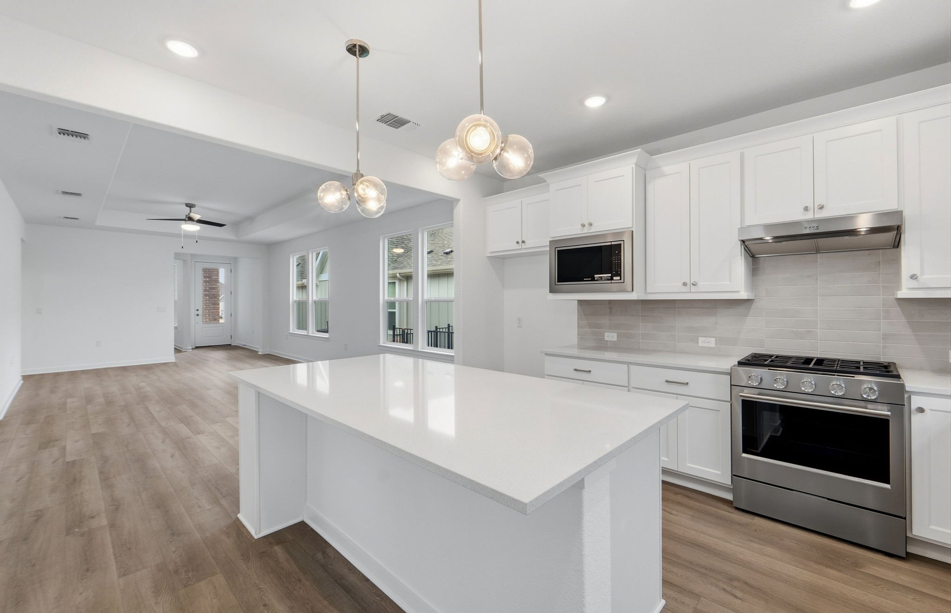 1010 Martingale Street Georgetown, TX 78633 - Photo 3 of 23 a large kitchen with cabinets wooden floor and stainless steel appliances