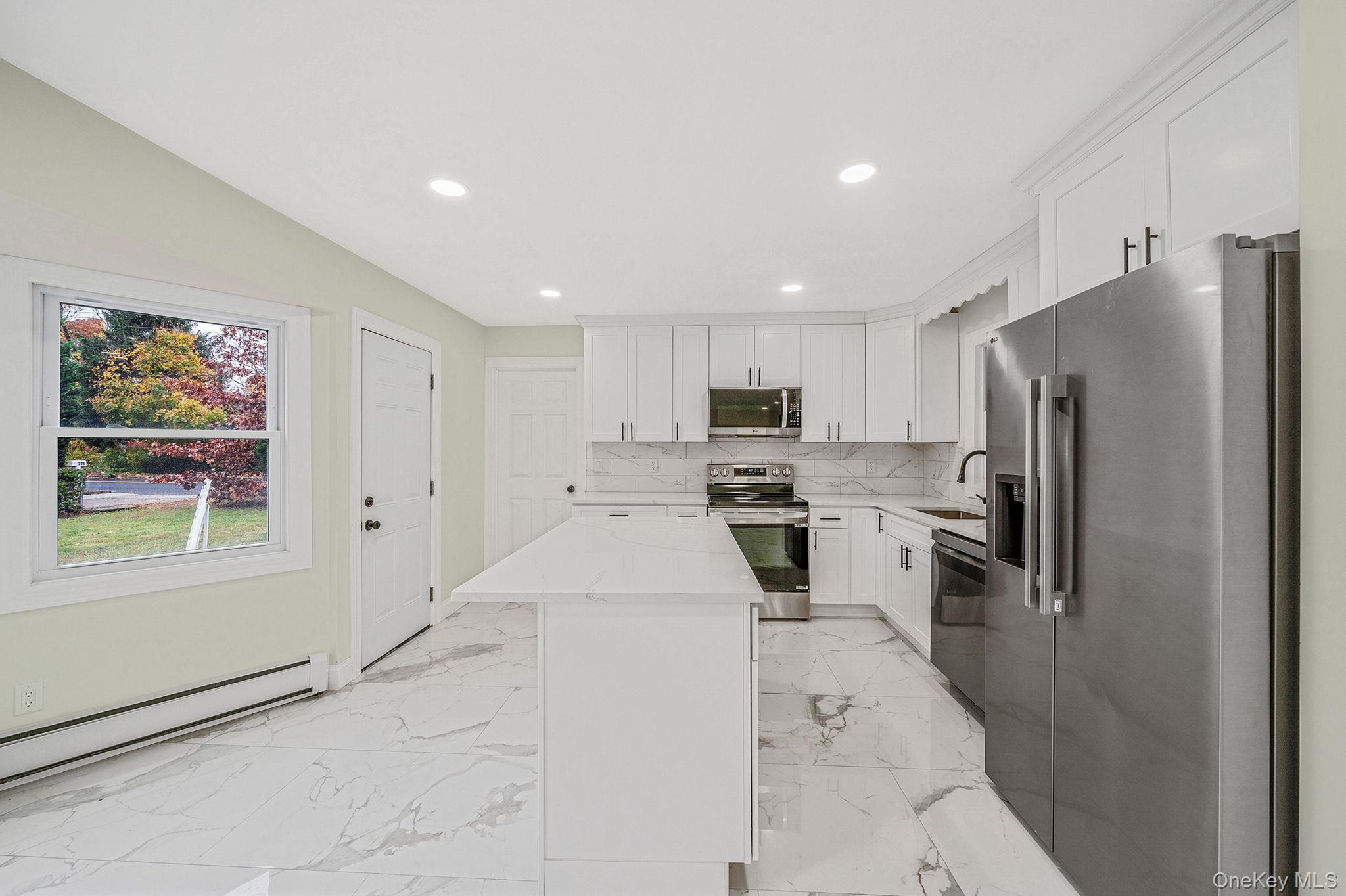 50 7th Street St. James, NY 11780 - Photo 11 of 25 a kitchen with stainless steel appliances a refrigerator and a stove top oven