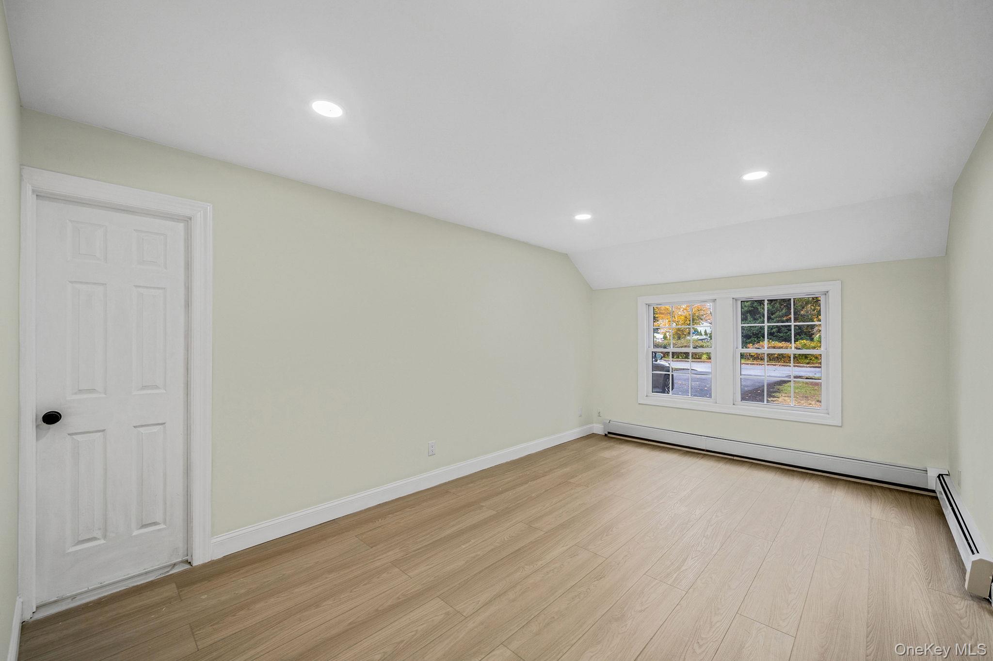 50 7th Street St. James, NY 11780 - Photo 19 of 25 an empty room with wooden floor and windows