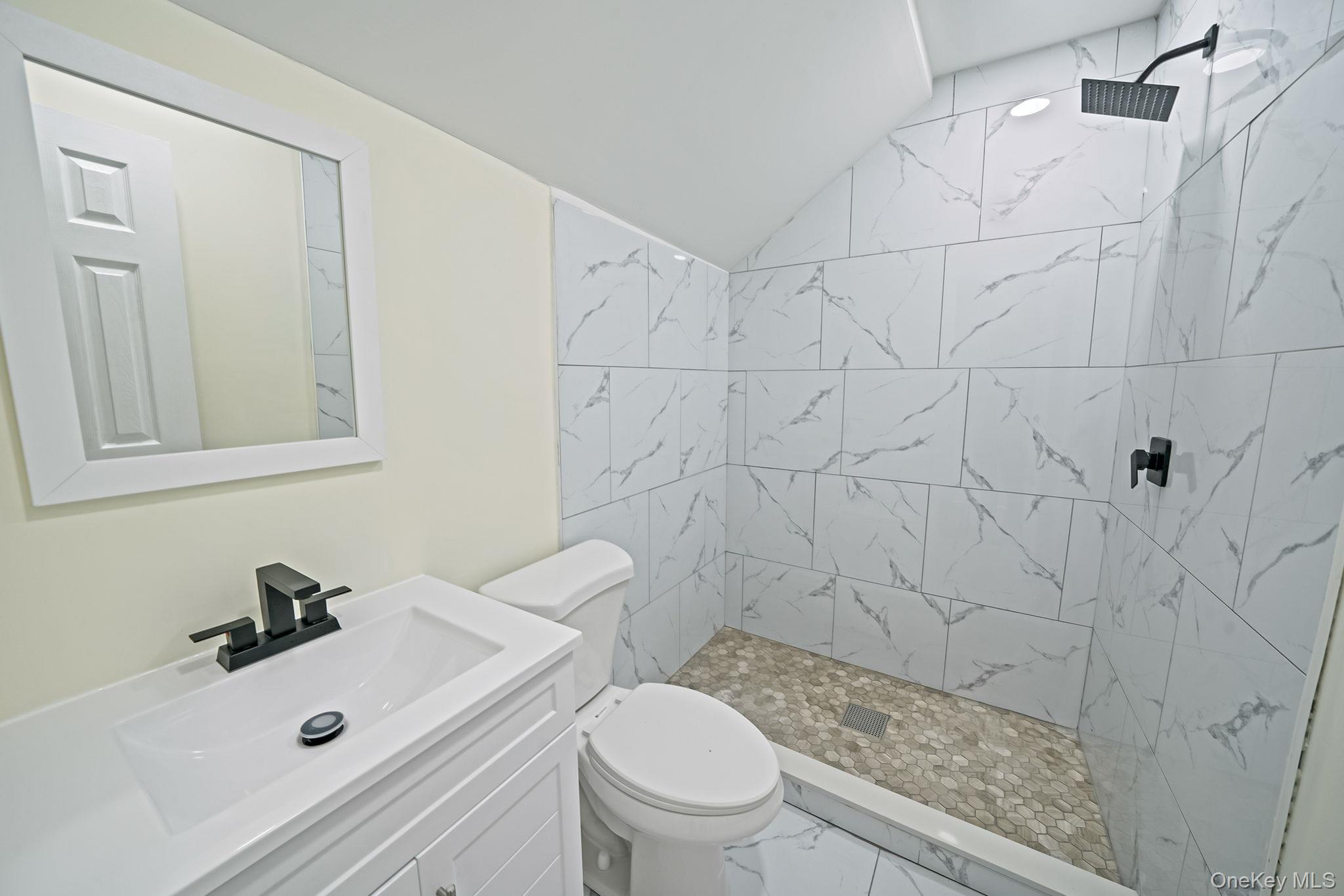 50 7th Street St. James, NY 11780 - Photo 21 of 25 a bathroom with a sink a toilet and shower