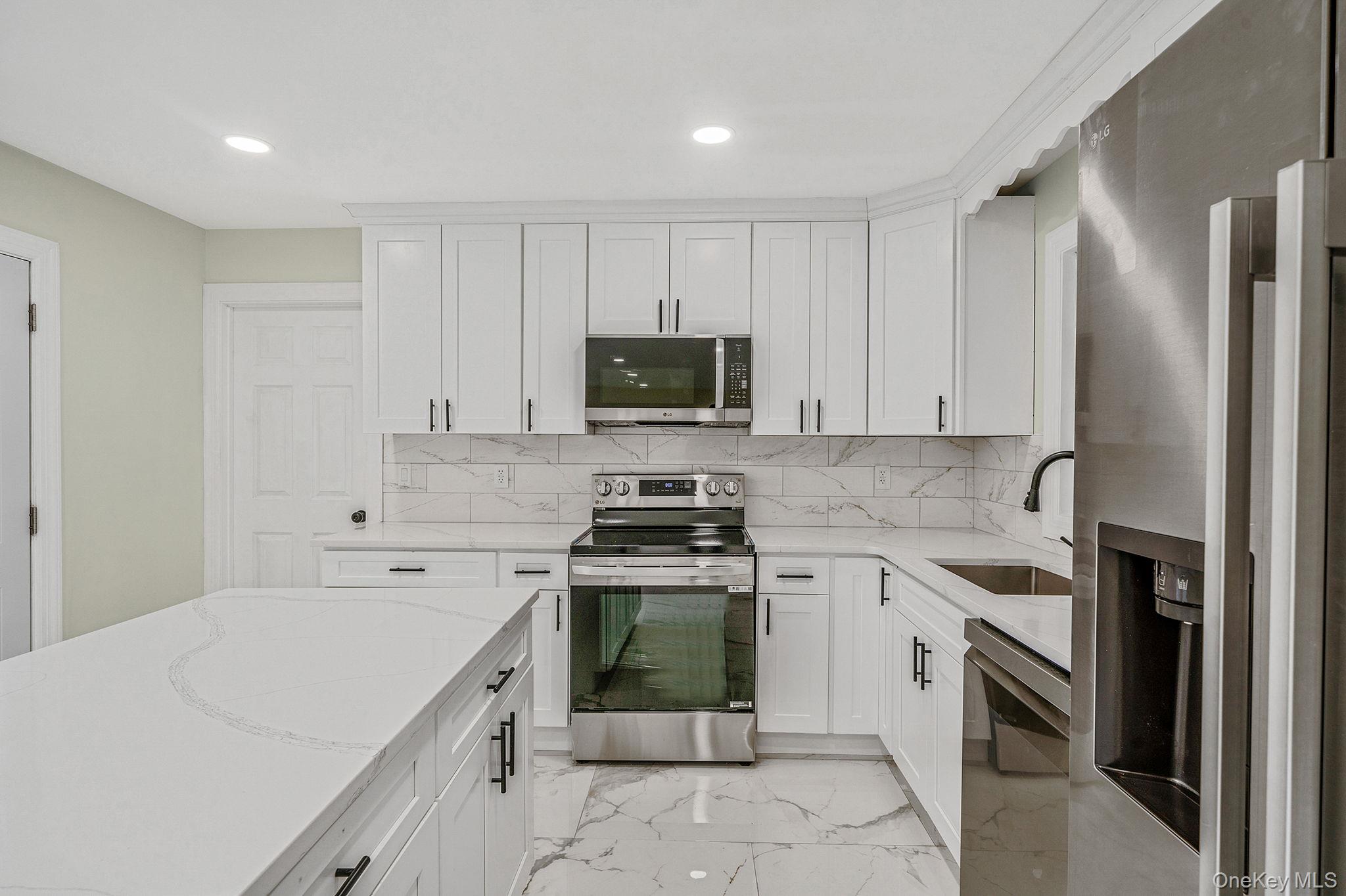 50 7th Street St. James, NY 11780 - Photo 4 of 25 a kitchen with a sink stove and refrigerator