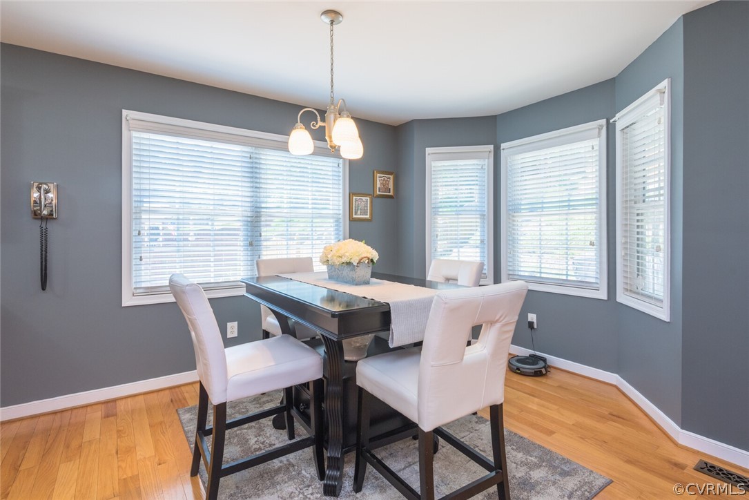 11616 Hillside Road Chester, VA 23831 - Photo 12 of 42 a dining room with furniture a chandelier and wooden floor