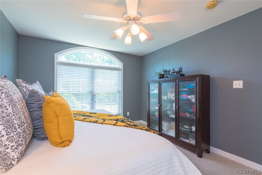 11616 Hillside Road Chester, VA 23831 - Photo 25 of 42 a bedroom with a large bed and a chandelier