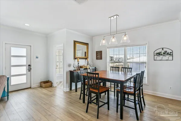 a view of a a dining room with furniture window and wooden floor