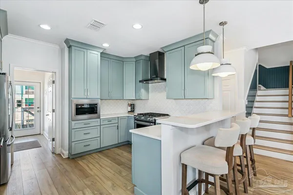 a kitchen with white cabinets and stainless steel appliances