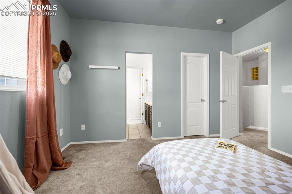 3254 Apogee View Colorado Springs, CO 80906 - Photo 16 of 28 a bedroom with a bed and a mirror