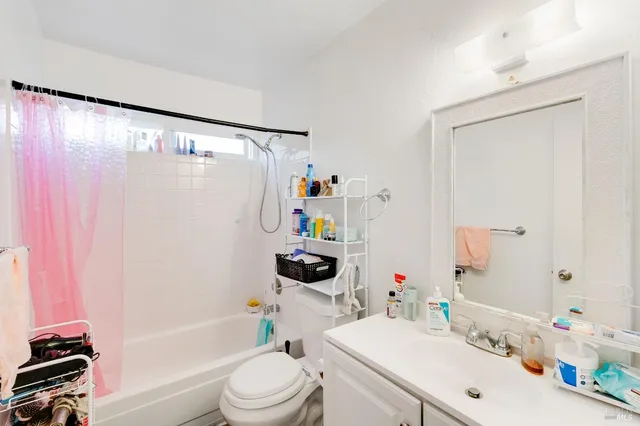 a bathroom with a sink a toilet a tub and shower curtain