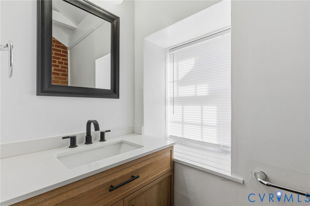 5116 Alberene Road Richmond, VA 23224 - Photo 11 of 20 a bathroom with a sink a vanity and a large mirror
