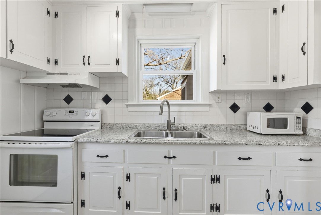 5116 Alberene Road Richmond, VA 23224 - Photo 8 of 20 a kitchen with stainless steel appliances granite countertop a sink stove and white cabinets