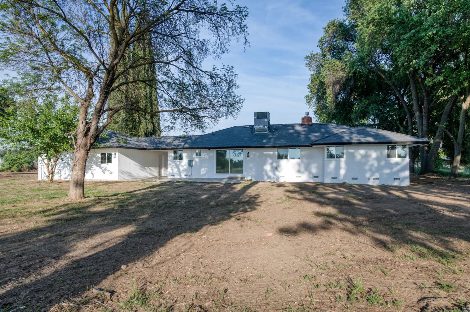 545 North Rio Vista Avenue Sanger, CA 93657 - Photo 19 of 46 a view of a house with a large tree next to a road