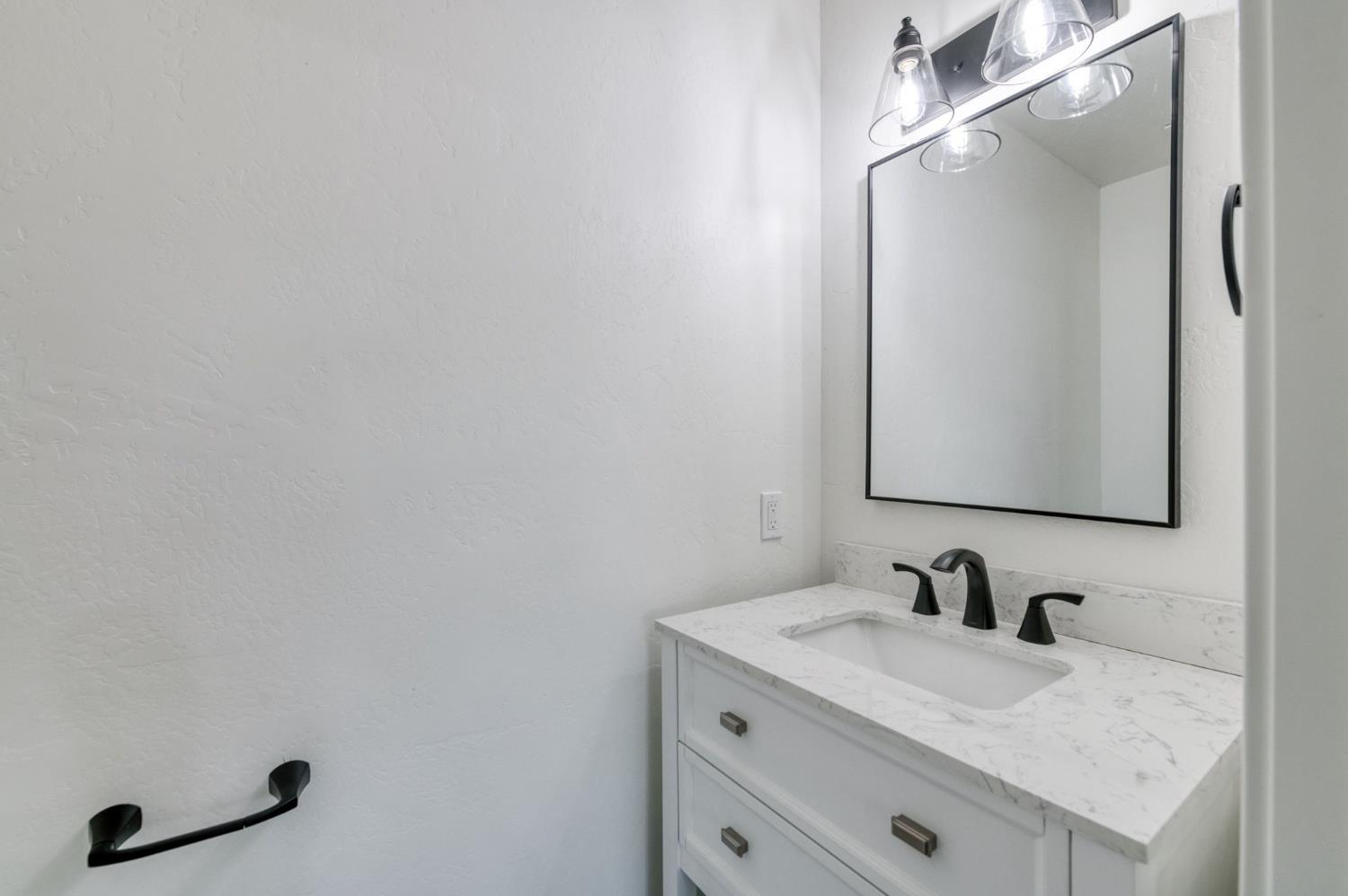 545 North Rio Vista Avenue Sanger, CA 93657 - Photo 25 of 46 a bathroom with a granite countertop sink and a mirror