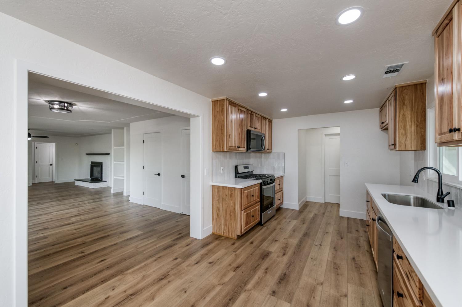 545 North Rio Vista Avenue Sanger, CA 93657 - Photo 26 of 46 a kitchen with stainless steel appliances granite countertop a sink stove and wooden floor
