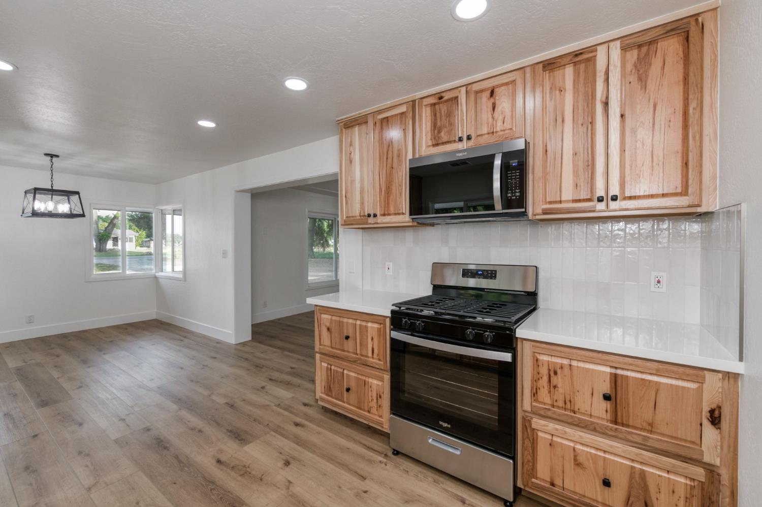545 North Rio Vista Avenue Sanger, CA 93657 - Photo 27 of 46 a kitchen with granite countertop wooden cabinets and a stove top oven