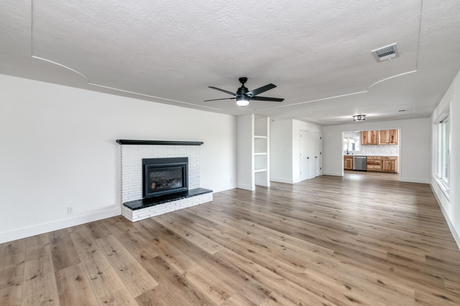 545 North Rio Vista Avenue Sanger, CA 93657 - Photo 5 of 46 wooden floor in an empty room with a fireplace