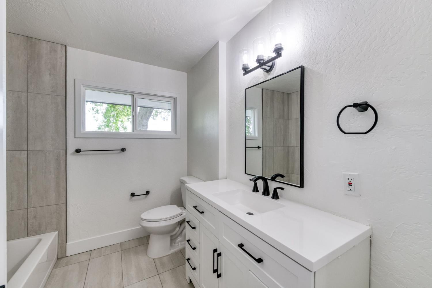 545 North Rio Vista Avenue Sanger, CA 93657 - Photo 8 of 46 a bathroom with a sink a toilet and a mirror
