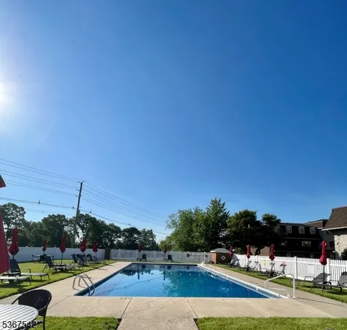 a view of swimming pool with seating area and trees