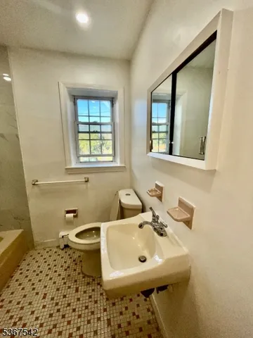 a bathroom with a sink toilet and mirror